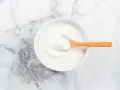 Schüssel mit weißem Pulver, das Kollagenpeptide enthält. Die Wirkung von Kollagenpeptiden ist vielfältig.