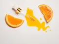 Orangenscheiben und ein Pipetten-Serum auf weißem Hintergrund. Vorsicht bei zu viel Vitamin C für die Haut, es kann Reizungen verursachen.